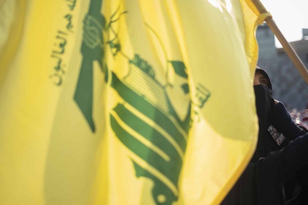 تصویر سرباز و پرچم حزب‌الله- از مقاله اوتولنگی در سایت بنیاد دفاع از دموکراسی